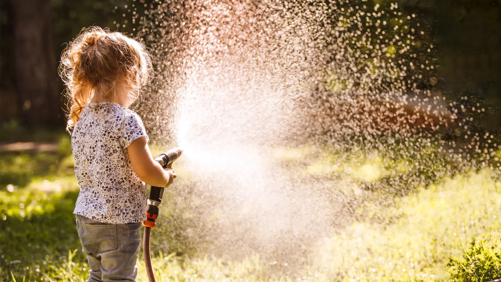 Young girl with garden hose