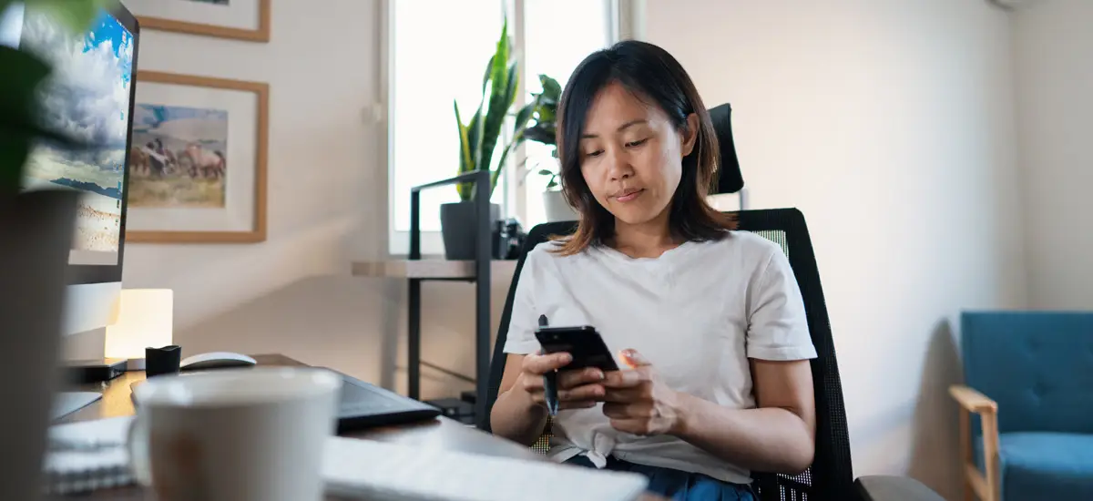 Woman working from home on smart phone